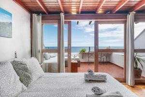a bedroom with a bed with a view of the ocean at Casa Roque in Haría