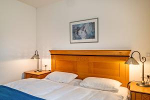 a bedroom with two beds with white sheets and two lamps at Oewern Diek in Wustrow