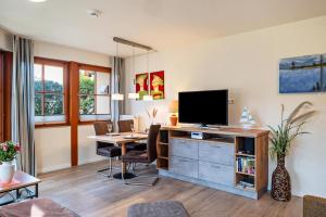 a living room with a desk with a tv and a computer at Oewern Diek in Wustrow