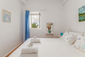 a bedroom with a white bed with towels on it at Margaret House in Parikia