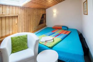 a small room with a bed and a chair at Ferienwohnung Säntisblick in Daisendorf