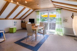 a dining room with a table and chairs and a window at Ferienwohnung Säntisblick in Daisendorf
