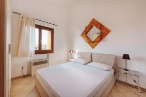 a bedroom with a large white bed in a room at Casa Vacanze Pistacchio in Murta Maria