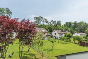a house on a hill with trees and grass at Ferienwohnung Säntisblick in Daisendorf