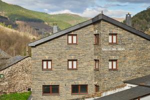 a large brick building with a sign on it at Valle del Ibias - Primero Derecha in Cecos
