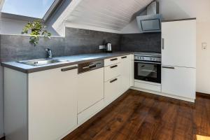 a kitchen with white cabinets and a sink at Ülger in Pfullendorf