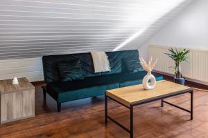 a living room with a green couch and a table at Ülger in Pfullendorf