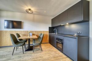a kitchen with a table and chairs and a table and a counter at Chalet Schlossberg Rosengarten in Nova Ponente +13 photos