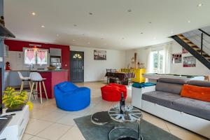 a living room with a couch and a kitchen at La maison dans les noyer in Sainte-Eulalie