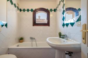 a bathroom with a sink and a bath tub and a sink at Villa Giada in Stintino