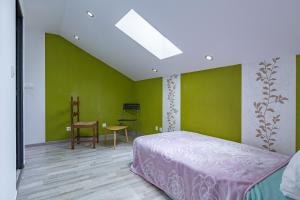 a bedroom with green walls and a bed and a table at La maison dans les noyer in Sainte-Eulalie +22 photos