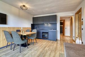 a kitchen and dining room with a table and chairs at Chalet Schlossberg Rosengarten in Nova Ponente