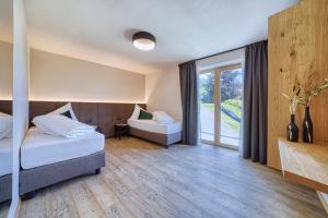 a bedroom with a bed and a couch and a window at Chalet Schlossberg Rosengarten in Nova Ponente
