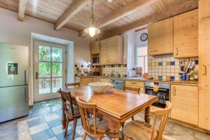 a large kitchen with a wooden table and chairs at Maison Abricot avec piscine in Aspiran