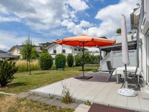 a patio with an umbrella and a table and chairs at Storchennest in Markdorf