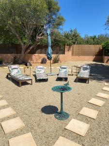 a patio with chairs and a table and an umbrella at Casa Amigos Rural in Cuevas del Almanzora