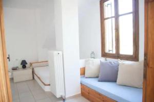 a blue bench in a room with a window at Maria's house 2 in Ilia