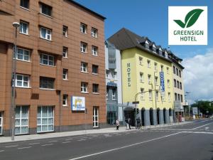 a building on the side of a street next to two buildings at City-Hotel Kurfürst Balduin in Koblenz