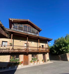a building with a balcony on the side of it at Posada Rural La Capellanía in Celis