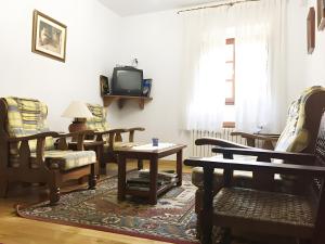 a living room with tables and chairs and a tv at Posada Rural La Capellanía in Celis