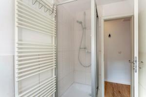 a white bathroom with a shower and a glass door at alter Speicher in Warendorf +8 photos
