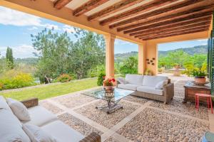 an outdoor patio with white couches and a glass table at Ca Nostra de Esporlas in Esporlas