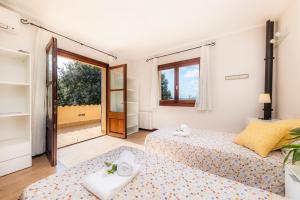 a bedroom with two beds and a window at Es Pujols in Artá +26 photos