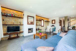 a living room with a blue couch and a tv at Es Pujols in Artá