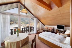 a bedroom with a bed and a table and a window at Haus Huber in Wolfach