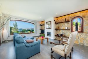 a living room with a blue couch and a stone wall at Es Pujols in Artá