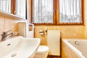 a bathroom with a sink and a toilet and windows at Ferienhaus Hebborn in Bergisch Gladbach +30 photos