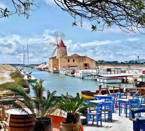 a marina with blue chairs and a windmill at Casa La Piazzetta in Marsala