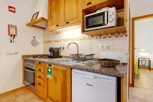 a small kitchen with a sink and a microwave at Monte do Tanoeiro - Casa da Barrica in Rogil