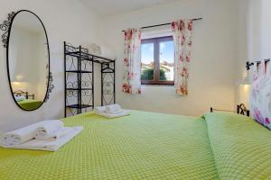 a bedroom with a green bed and a mirror at Monte do Tanoeiro - Casa da Barrica in Rogil