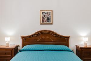 a bedroom with a bed with a blue bedspread and two lamps at Casa La Piazzetta in Marsala