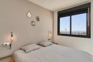 a bedroom with a bed and a large window at 2-bedroom apartment with seaview in Nerja +21 photos