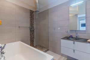 a bathroom with a shower and a tub and a sink at Maison Le Moulleau in Arcachon +17 photos