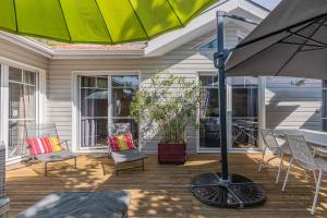 a patio with chairs and an umbrella on a house at Maison Le Moulleau in Arcachon