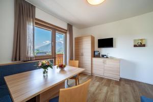 a hotel room with a table and a large window at Gartenheim App Leonhard in Schenna