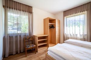 a bedroom with a bed and a desk and a window at Gartenheim App Leonhard in Schenna