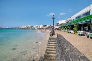 a beach with a street light next to the ocean at Apartamento La Estrella II in Playa Blanca