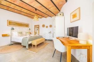 a bedroom with a bed and a desk and a television at Els Abats in Fornalutx +29 photos