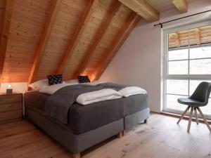 a bedroom with a large bed and a chair at Haus Mühlenfranzenhof in Schönwald