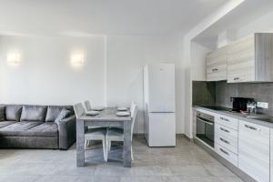 a kitchen with a table with chairs and a couch at Giuliano Superior 3 para 4 personas in Empuriabrava +13 photos