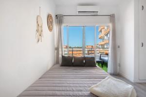 a bed in a room with a large window at Apartamento Saltillo Alto in Torremolinos +20 photos
