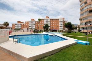 a swimming pool in a yard with buildings in the background at Apartamento Saltillo Alto in Torremolinos