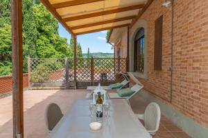 a patio with a table and chairs on a porch at Villa I Tigli - Pervinca in Campiglia Marittima