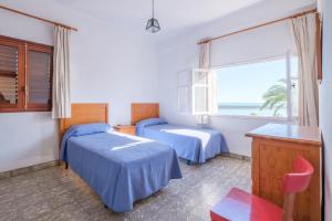 a bedroom with two beds and a window with the ocean at Apartamento las Palmeras 4 in Benicarló