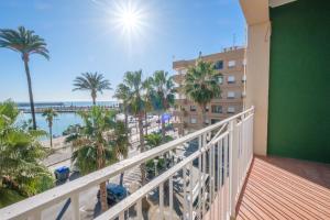 a balcony with a view of the beach and palm trees at Apartamento las Palmeras 4 in Benicarló