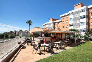 a patio with tables and chairs next to a building at Apartamento Saltillo Alto in Torremolinos